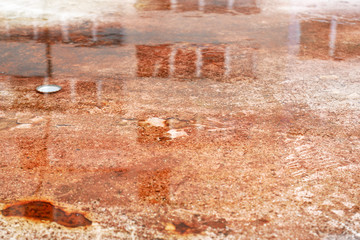 Urban background - reflections of a building in a puddle on a rusty container