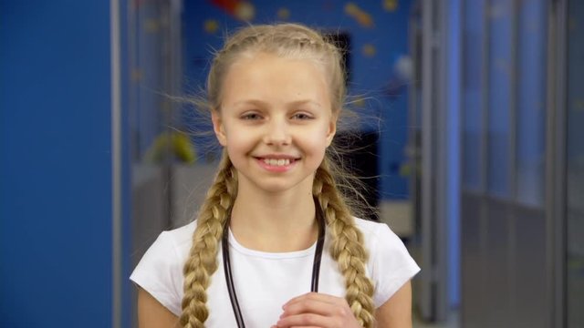 Girl smiling in a hospital corridor with phonendoscope