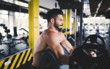 Fototapeta na wymiar Determined male working out in gym