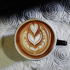Coffee cup with latte art on the abstact backgound