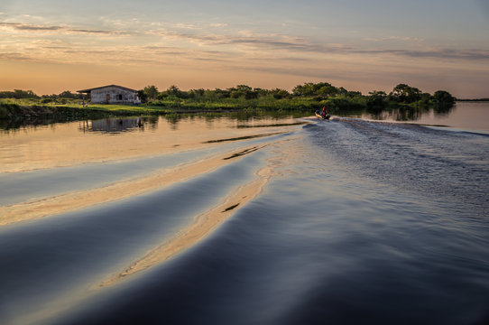 Small Motor Boat Making Waves At Sunset At Rio Paraguay