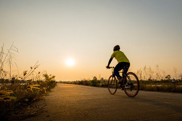 Fototapeta premium Silhouette of cyclist on sunset background