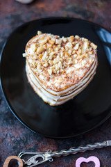 Beautiful heart cake ready to eat on black plate.