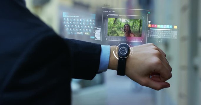 A man answers the wife who smiles and waves from the phone that appears in hologram clock futuristic and technological. Concept: network, communication,family, technology, augmented reality and future
