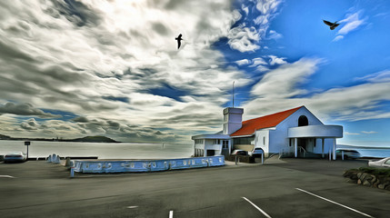 Obraz premium House on the shore with the sea in the background under a cloudy sky with birds overhead