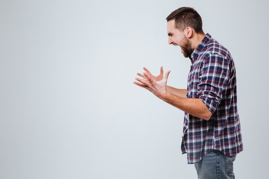 Side View Of Screaming Bearded Man In Shirt