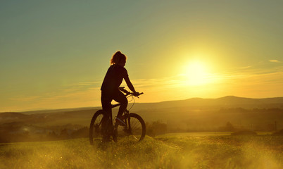 Girl on a bicycle in the sunset