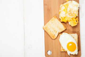 Toasts and egg on a white wooden table