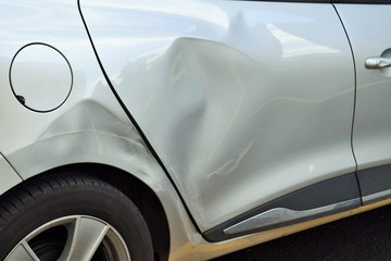 PKW mit Blechschaden nach Unfall an der hinteren Beifahrerseite in Nahaufnahme