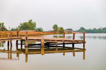 Landscape with wooden pier on the Troav Kot Lake, Cambodia. Sunset in pastel colors. © sonatalitravel