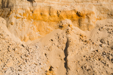 cliff of the yellow orange brown sand soil clay under the bright sunny day. Texture background