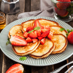 Homemade delicious pancakes served with fresh strawberries and honey