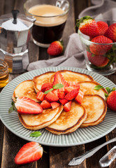 Homemade delicious pancakes served with fresh strawberries and honey
