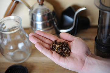 A handful of dried coffee berries cascara on the palm. Drip Coffee Maker, glass jug server in the...
