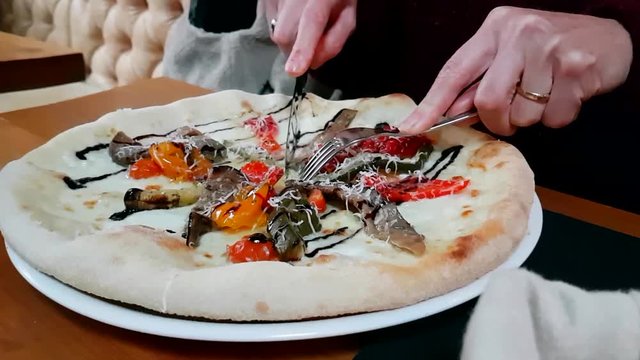 Woman Eating Vegetarian Pizza In Restaurant