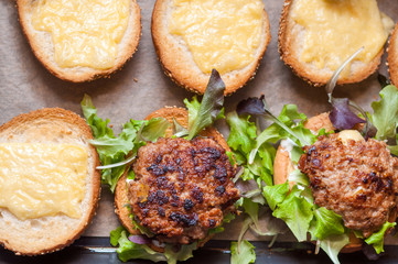 Delicious homemade hamburger with lettuce
and cheese in baking tray. Homemade dinner