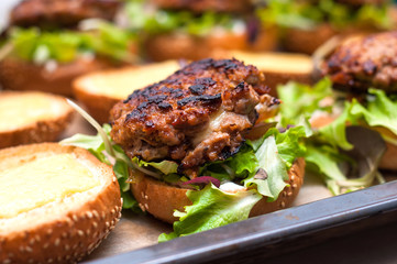 Delicious homemade hamburger with lettuce
and cheese in baking tray. Homemade dinner