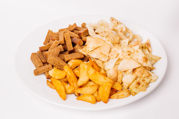 Fast food snacks composition with onion rings,  crackers, baked potatoes, chips, toast.