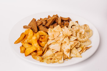 Fast food snacks composition with onion rings,  crackers, baked potatoes, chips, toast.