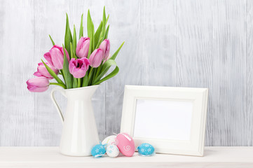 Easter eggs, photo frame and pink tulips