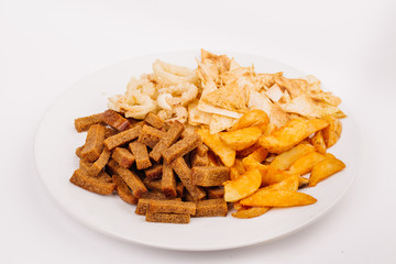 Fast food snacks composition with onion rings,  crackers, baked potatoes, chips, toast.