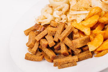 Fast food snacks composition with onion rings,  crackers, baked potatoes, chips, toast.