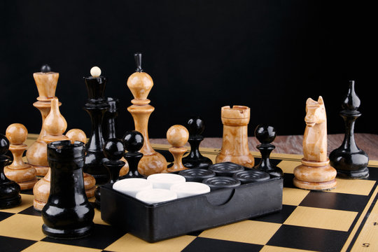 The chess pieces and set of checkers placed on the chessboard.