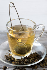 Green tea. Strainer. Grey wooden background. Copy space