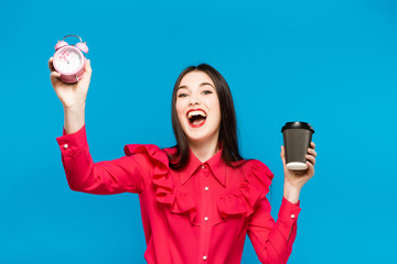 Fashion pretty woman with coffee cup in colorful clothes over blue background wearing a pink