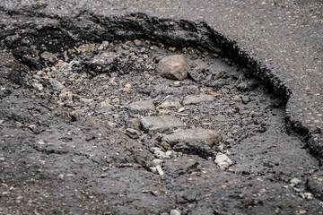Pot-hole in tarmac road / street / - hole in the road / winter damage / roads in early spring
