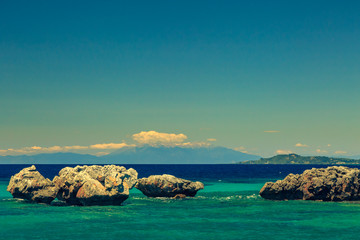Fototapeta na wymiar The rocky coast overlooking the turquoise blue sea in warm summer day. Greece. Chalkidki