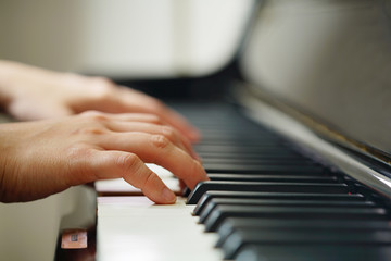 Fototapeta premium Scene of pianist hands from beside angle with shallow depth of field playing piano. Selective focused.