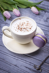 Homemade coffee cappuccino with true ceylon cinnamon, macaron and tulips