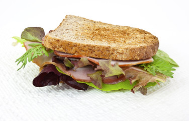 Simple ham sandwich with lettuce on toasted whole wheat bread. Isolated.