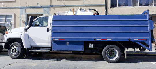 Blue utility restoration truck parked on urban street.