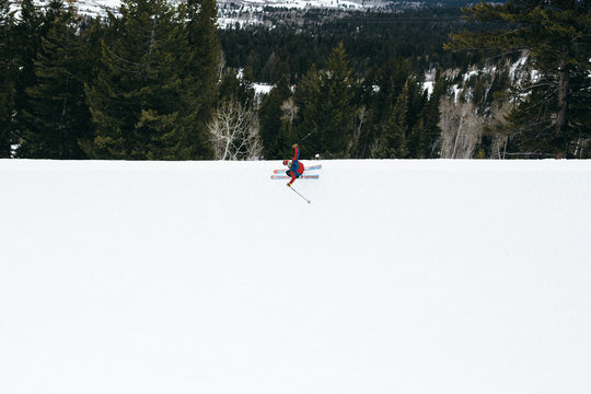 Aerial view of skier on flat snowy surface 