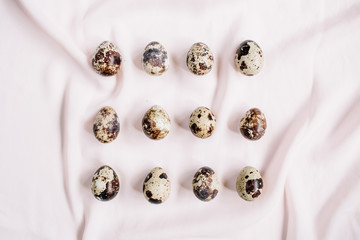 Quail eggs on pink textile background. Flat lay, top view. Easter concept.