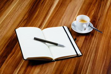 Notizbuch, Stift und Kaffeetasse auf Holztisch