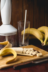 Ingredients for banana smoothies: Bananas, blender on dark rust