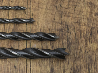 Drill bits on wooden background