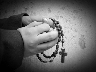 Young women praying with rosary in the palms