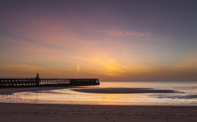 Naklejka premium Sunrise over Blyth Piers and beach at Blyth, Northumberland, England, Uk.