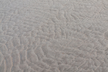 Ripple patterns left is sandy beach by receding tide.