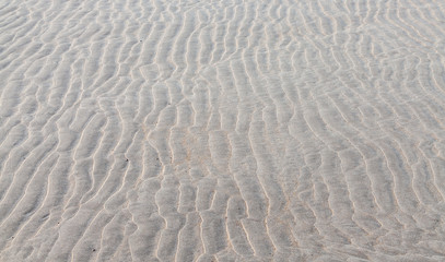 Fototapeta na wymiar Ripple patterns left is sandy beach by receding tide.