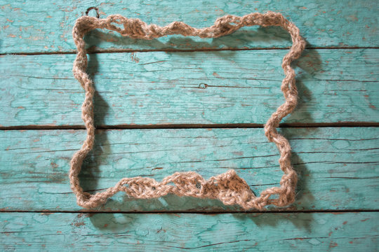 Frame made of rope on a green wooden boards
