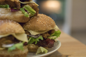 Chickenburgers with cheese, bacon and salad on a plate