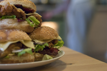 Chickenburgers with cheese, bacon and salad on a plate