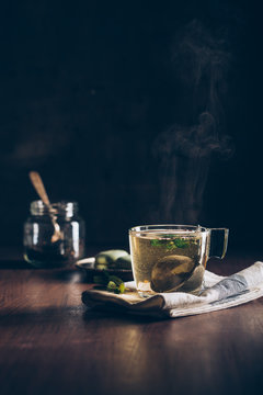 Steaming cup of tea on dark background
