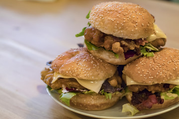 Chickenburgers with cheese, bacon and salad on a plate
