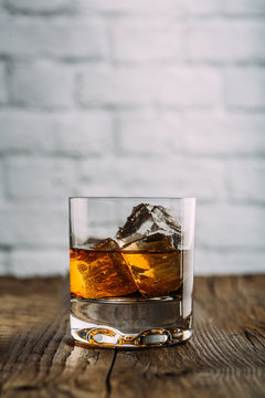 Glass of whiskey on a wooden table